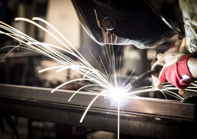 Welder fabricating a metal assembly